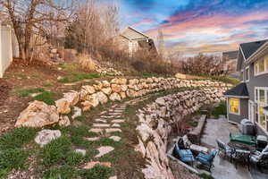 Yard at dusk featuring a fenced backyard, a patio, and an outdoor living space