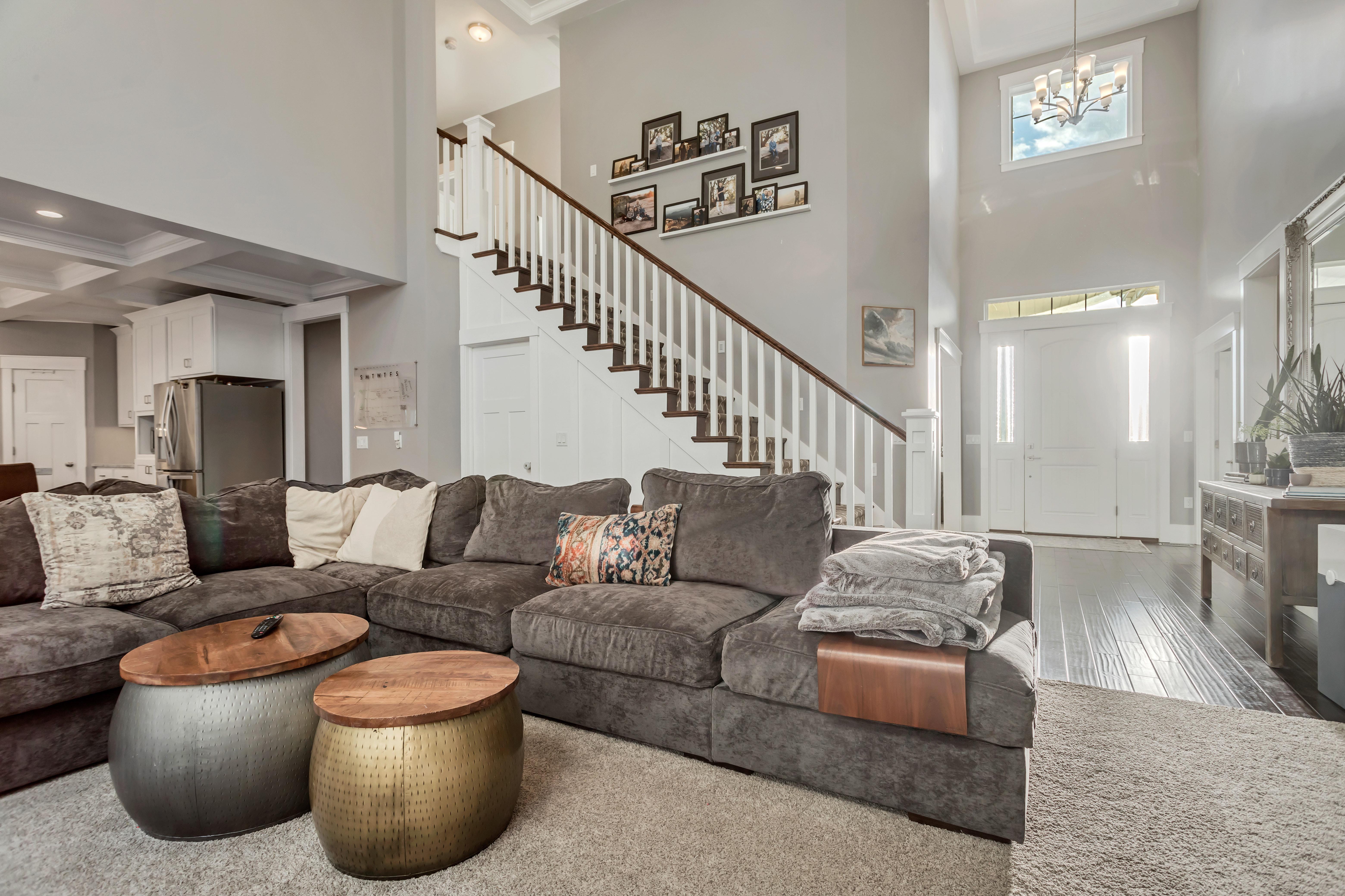 Living room with a chandelier, wood finished floors, and high coffered ceiling