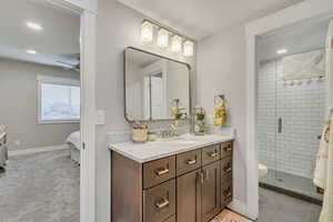Ensuite bathroom featuring recessed lighting, vanity, a stall shower, and a ceiling fan