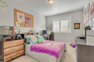 Bedroom with a desk and light colored carpet