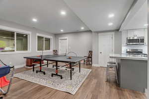 Game room featuring light wood-type flooring and recessed lighting