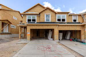 New construction residential property featuring a multi-gable roofline and sheathed exterior walls