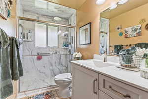 Bathroom with updated vanity and a walk-n marble finish shower.