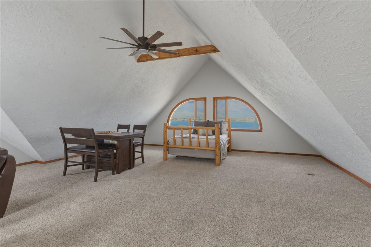 Bedroom featuring light colored carpet, a textured wall, ceiling fan, and a textured ceiling