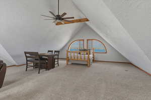 Bedroom featuring light colored carpet, a textured wall, ceiling fan, and a textured ceiling