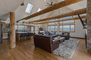 Living area featuring wood finished floors, a ceiling fan, and a skylight