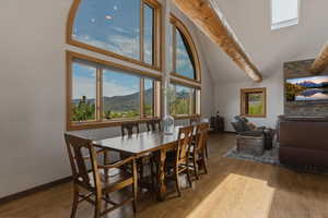 Dining area with light wood finished floors and lofted ceiling
