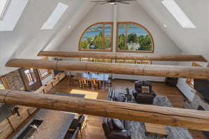 Living area with a skylight, wood-type flooring, and plenty of natural light