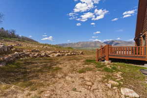 View of yard with a deck with mountain view