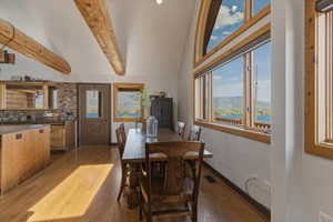 Dining area featuring dark wood-style flooring, plenty of natural light, a mountain view, and lofted ceiling