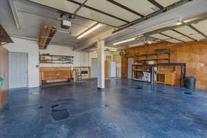 Garage with wooden walls and freestanding refrigerator