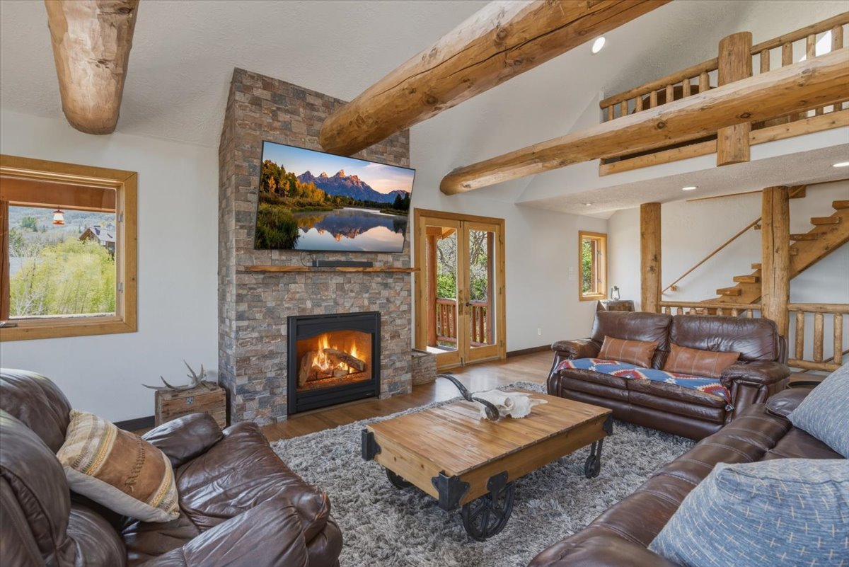 Living room featuring wood finished floors and a stone fireplace