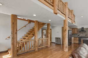 Stairway featuring wood finished floors and recessed lighting