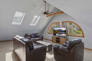 Carpeted living room featuring lofted ceiling and ceiling fan