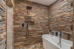 Full bathroom with a freestanding tub and tiled shower