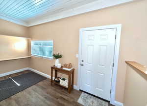 Entrance foyer with dark wood-style floors and wooden ceiling