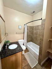 Full bath featuring vanity and shower / bath combination with curtain
