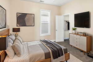 Bedroom featuring dark colored carpet and baseboards