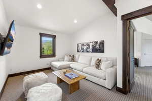 Carpeted living room featuring lofted ceiling and recessed lighting