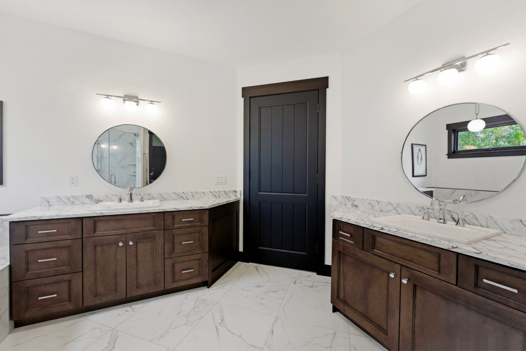 Bathroom featuring two vanities and light marble finish floors