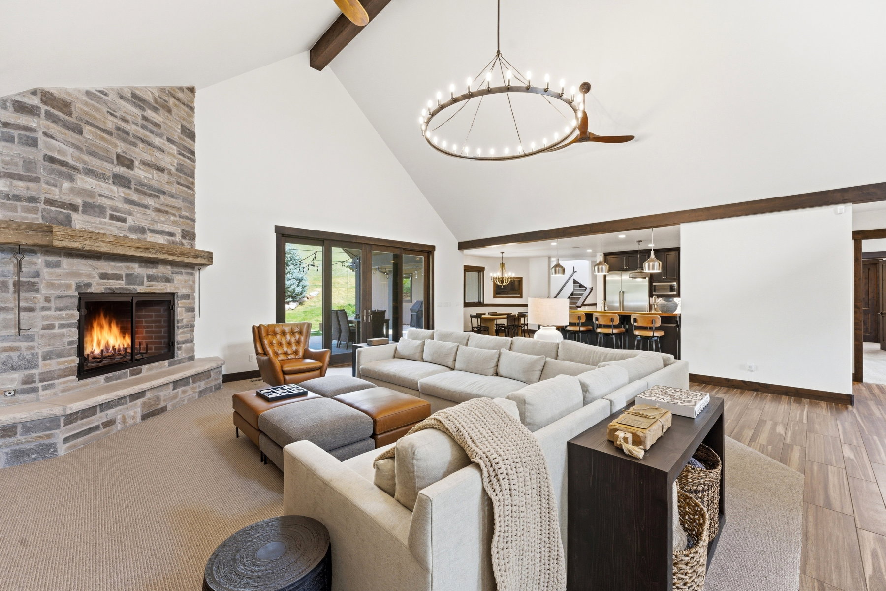 Living room featuring a stone fireplace and a chandelier