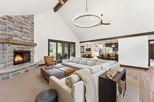 Living room featuring a stone fireplace and a chandelier