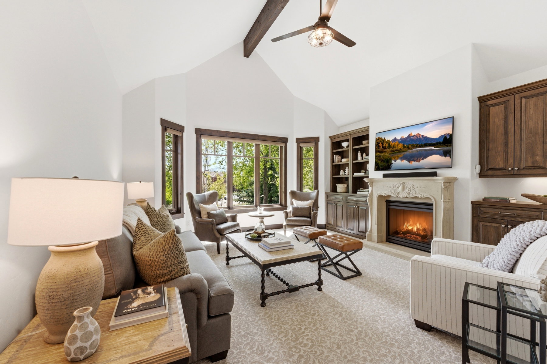 Living area with ceiling fan, a fireplace, and built in shelves