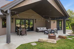 View of patio with french doors, an outdoor living / dining area, and a fire pit