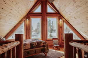 Bedroom with wood ceiling, wood-type flooring, and log walls