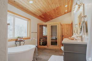 Bathroom featuring a sauna, vanity, a freestanding tub, recessed lighting, and a vaulted wood ceiling