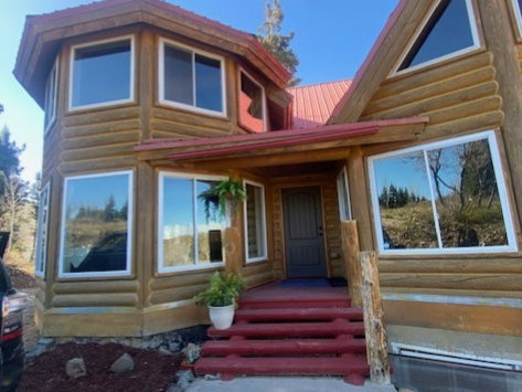 Log-style exterior featuring a red metal roof and white-framed windows