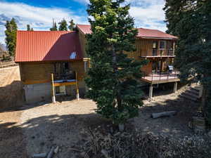Back of property with a metal roof and a balcony