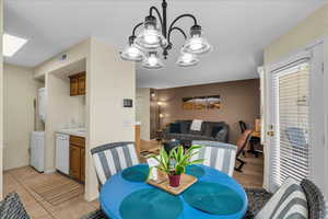 Dining area with stacked washer / drying machine and suspended lighting