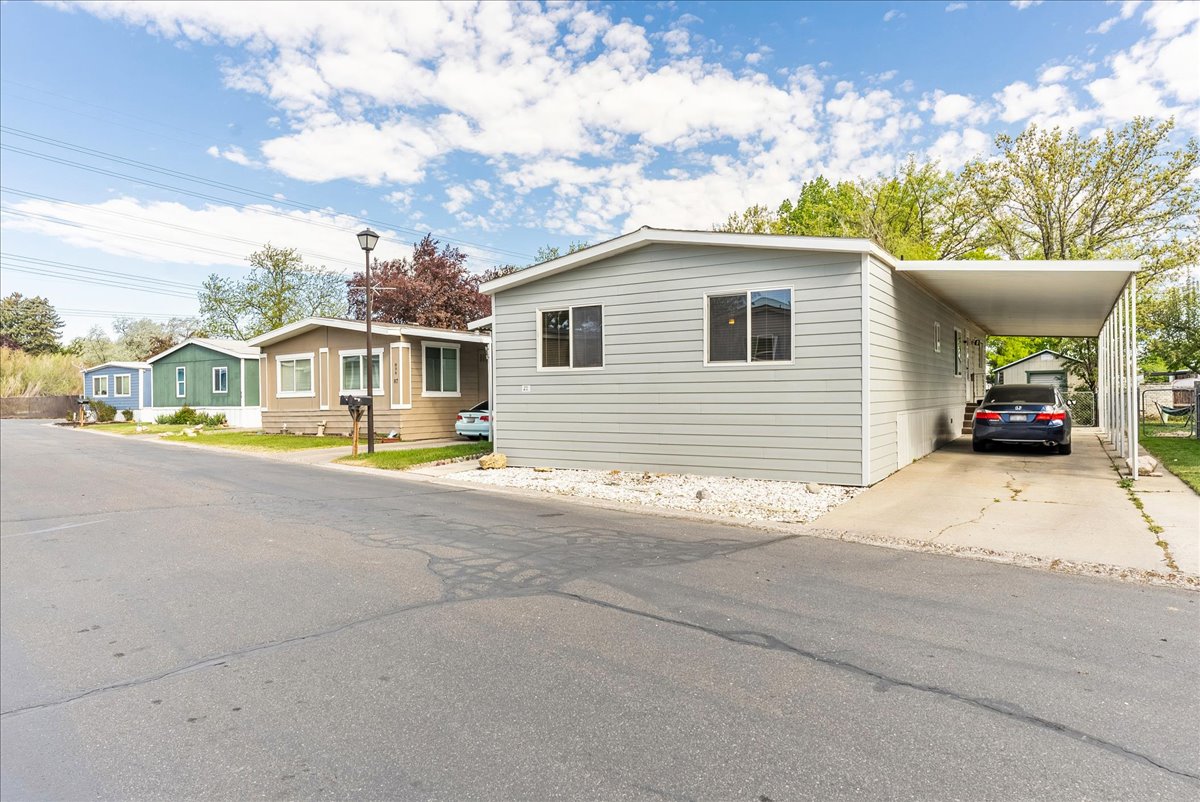 Manufactured / mobile home featuring a carport and driveway