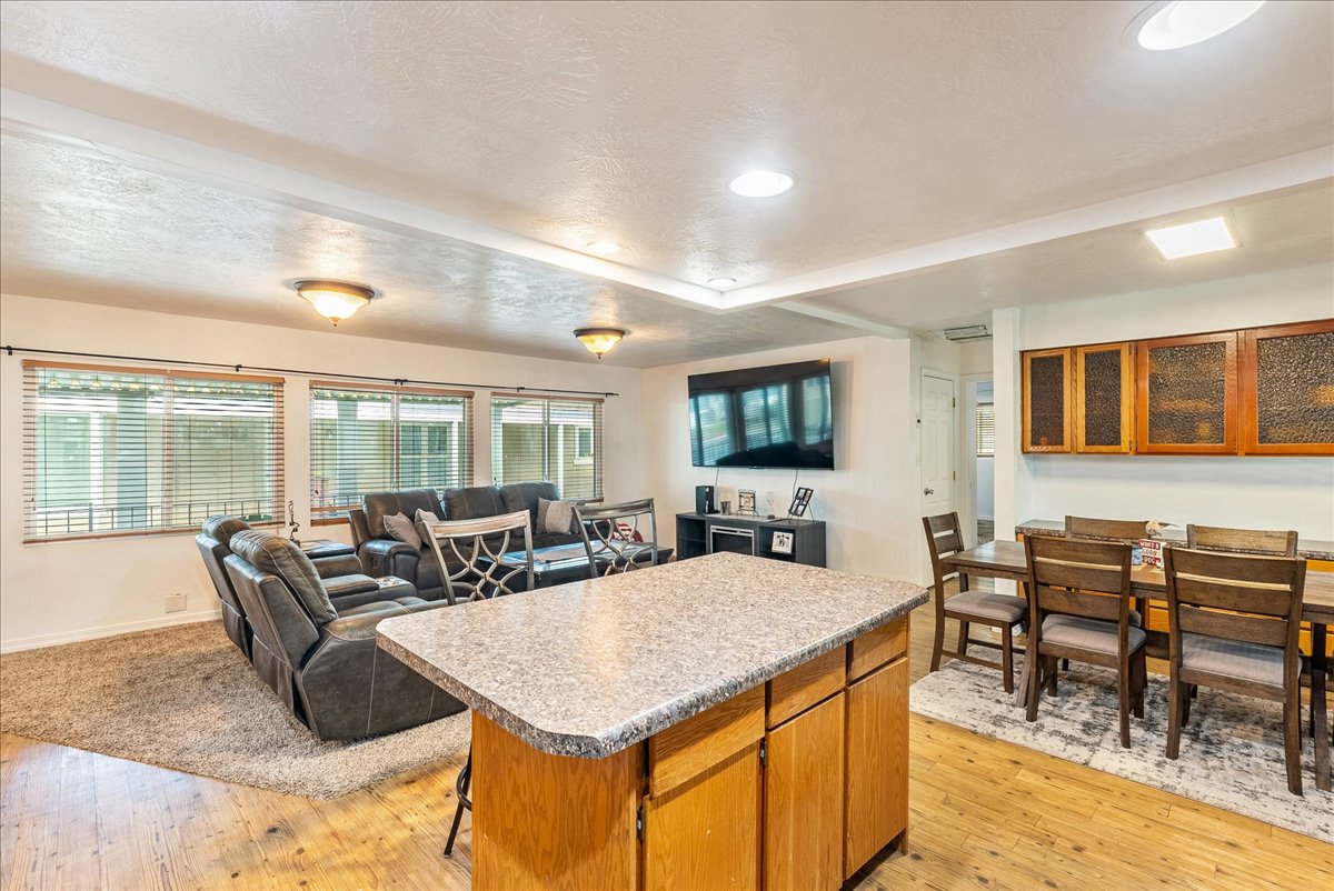 Kitchen with wood finish cabinetry, open floor plan, light wood-style floors, a kitchen island, and a kitchen bar