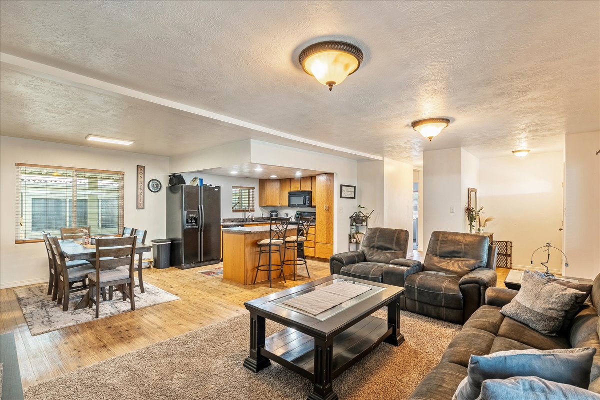 Living area featuring light wood finished floors and a textured ceiling