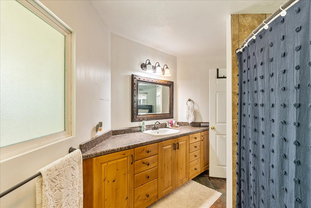Full bathroom with vanity and a shower with shower curtain
