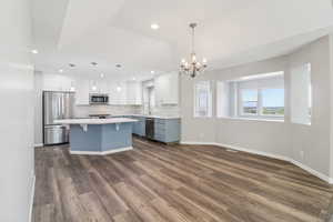 Kitchen with stainless steel appliances, suspended lighting, a breakfast bar area, plenty of natural light, and two tone cabinets