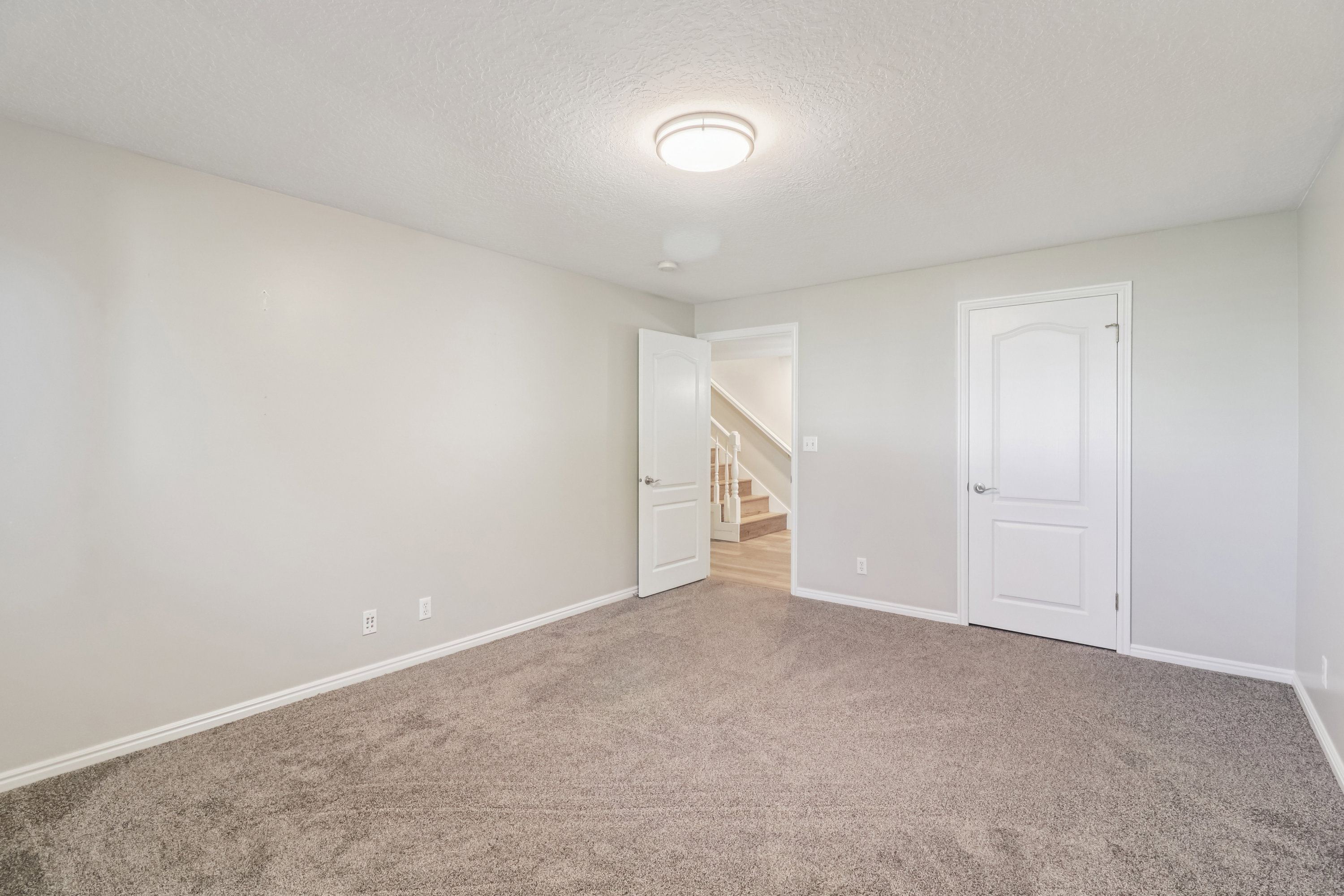 Unfurnished bedroom with carpet floors and a textured ceiling