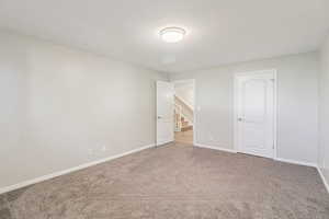 Unfurnished bedroom with carpet floors and a textured ceiling