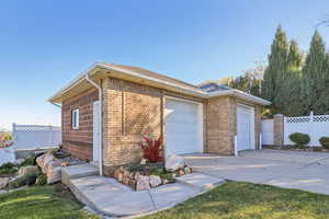 View of side of home featuring brick siding and concrete driveway