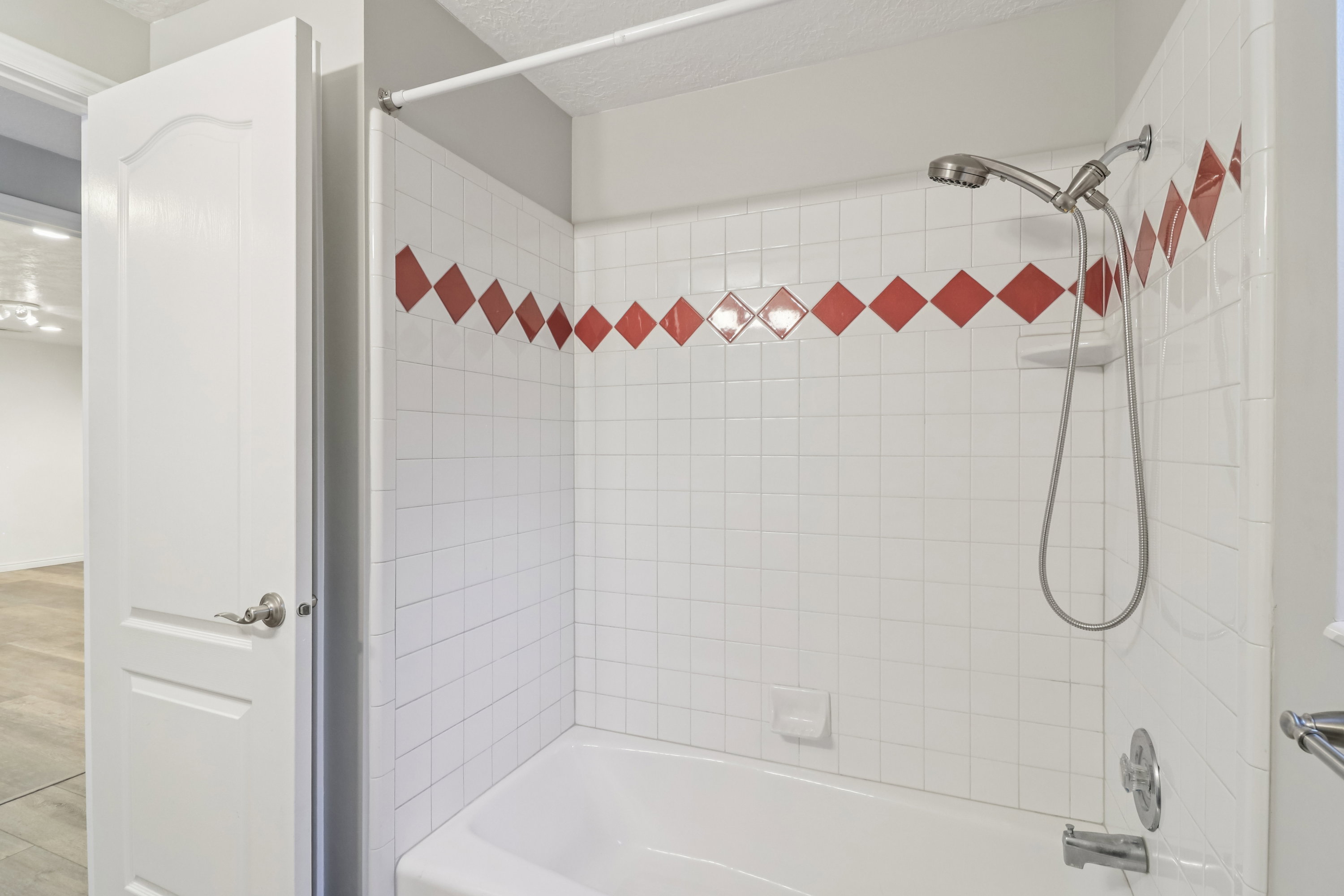 Bathroom with washtub / shower combination and a textured ceiling