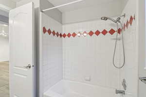 Bathroom with washtub / shower combination and a textured ceiling