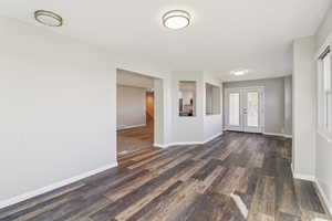 Foyer entrance featuring dark wood-style floors and french doors