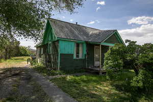 View of front of house with a front lawn and roof with shingles