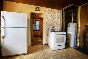 Kitchen with white appliances, gas water heater, and light flooring