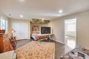 Bedroom featuring concrete floors, a closet, and recessed lighting