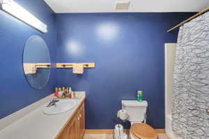 Bathroom featuring vanity and shower / bath combination with curtain
