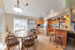Dining room featuring vaulted ceiling and light wood-style floors