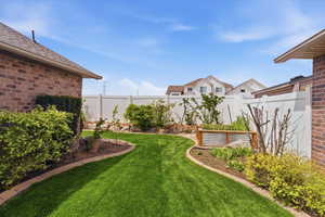 Fenced backyard featuring a garden